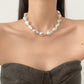 Voeg een vleugje licht toe aan je stijl met de elegante resin ketting met parelmoereffect