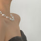 Voeg een vleugje licht toe aan je stijl met de elegante resin ketting met parelmoereffect