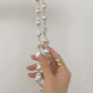 Voeg een vleugje licht toe aan je stijl met de elegante resin ketting met parelmoereffect