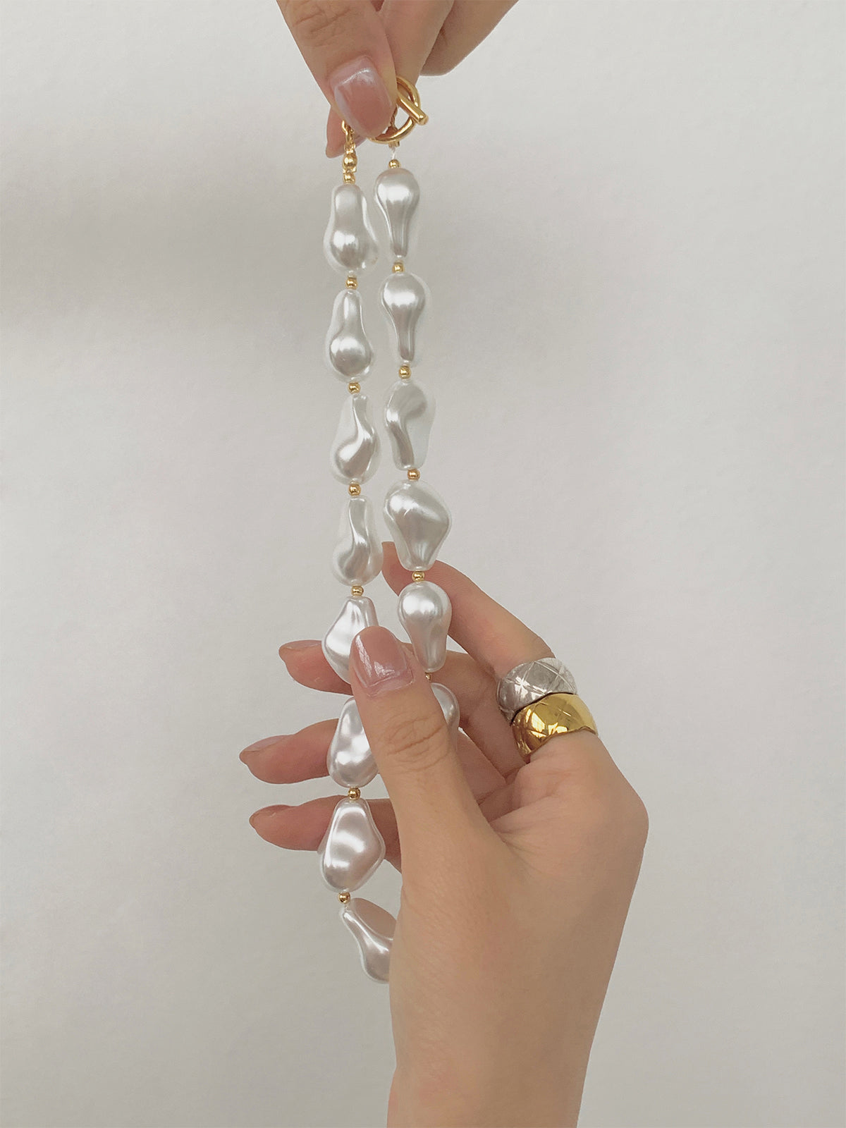 Voeg een vleugje licht toe aan je stijl met de elegante resin ketting met parelmoereffect