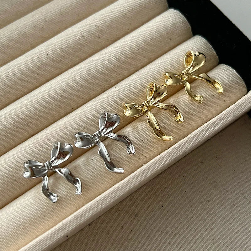 Zilverkleurige Strik Oorbellen – Speels & Vrouwelijk Design met Glanzende Afwerking